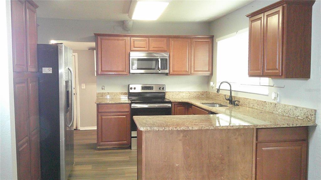 4609 Gallagher Road Plant City, FL 33565 - Photo 11 of 23 a kitchen with stainless steel appliances granite countertop a refrigerator sink and stove