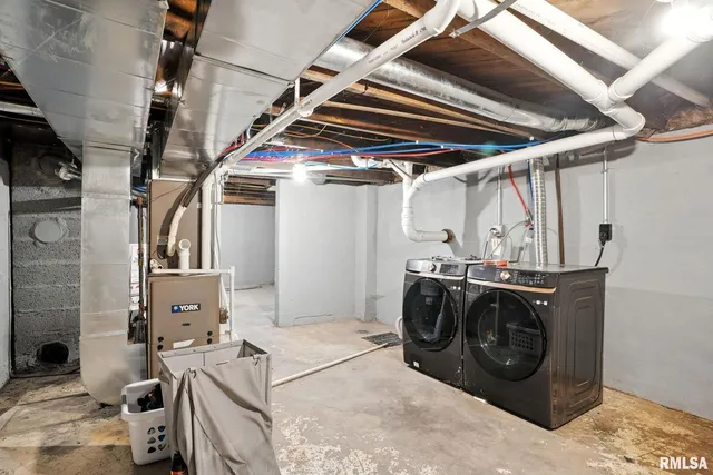 a utility room with stainless steel appliances kitchen island granite countertop a sink and cabinets