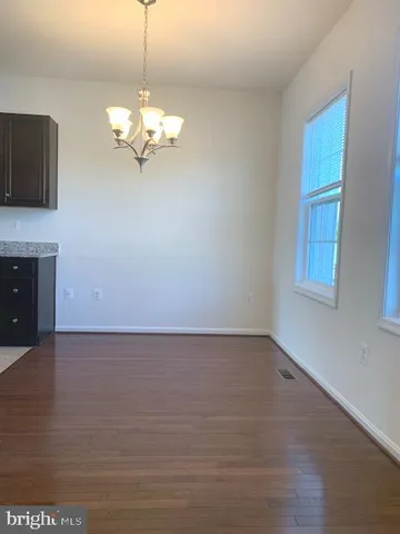 a view of a room with wooden floor and chandelier