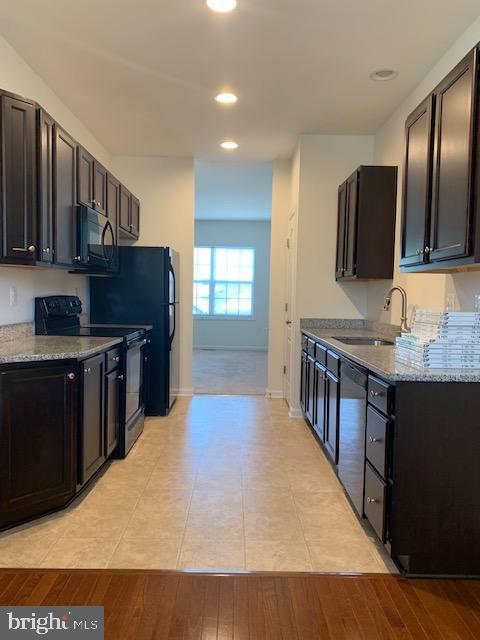17275 Library Boulevard Ruther Glen, VA 22546 - Photo 4 of 18 a kitchen with stainless steel appliances granite countertop a stove a sink and a microwave