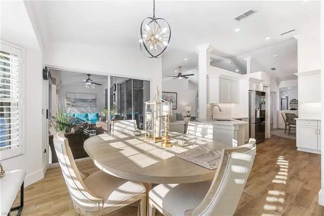 a view of a dining room with furniture a chandelier and wooden floor