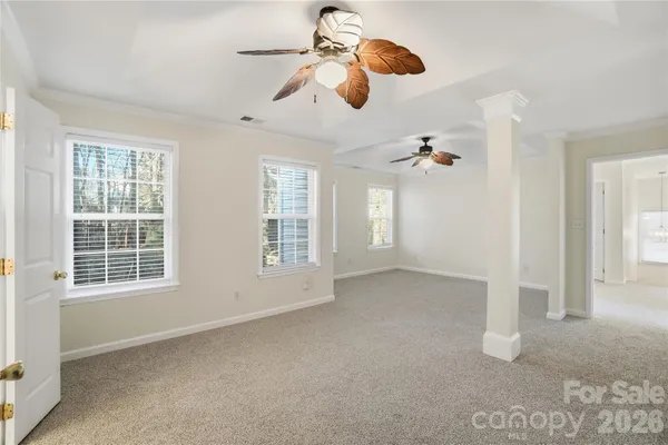 an empty room with windows and fan