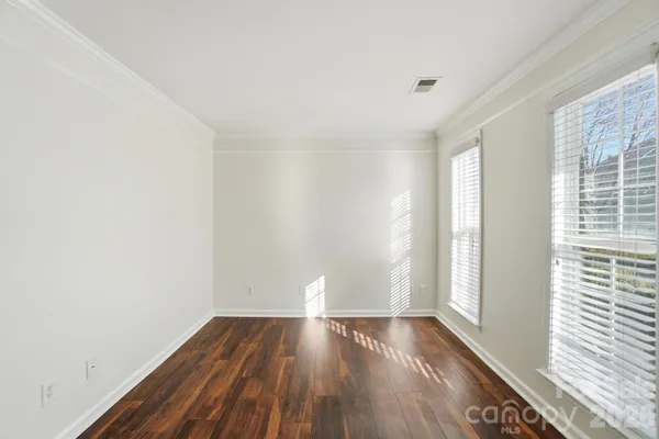 a view of wooden floor and window in a room