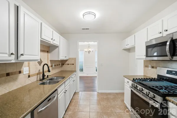 a kitchen with stainless steel appliances granite countertop a sink stove and cabinets