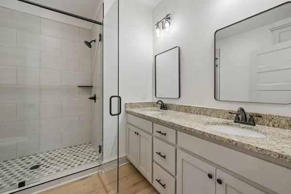 a bathroom with a shower sink and mirror