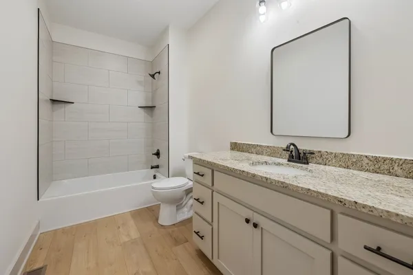 a bathroom with a granite countertop sink toilet and shower