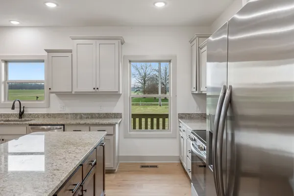 a kitchen with kitchen island a counter top space a sink stainless steel appliances and cabinets