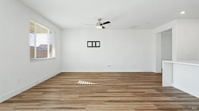 a view of a room with wooden floor and a ceiling fan