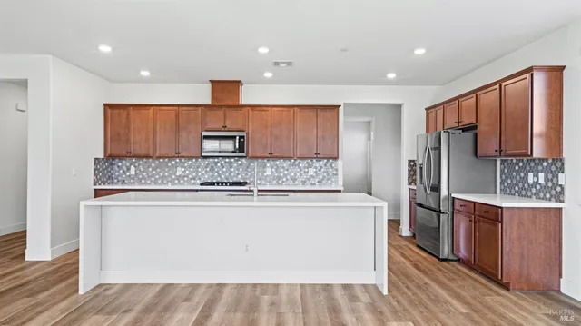 a kitchen with stainless steel appliances granite countertop a stove and a refrigerator