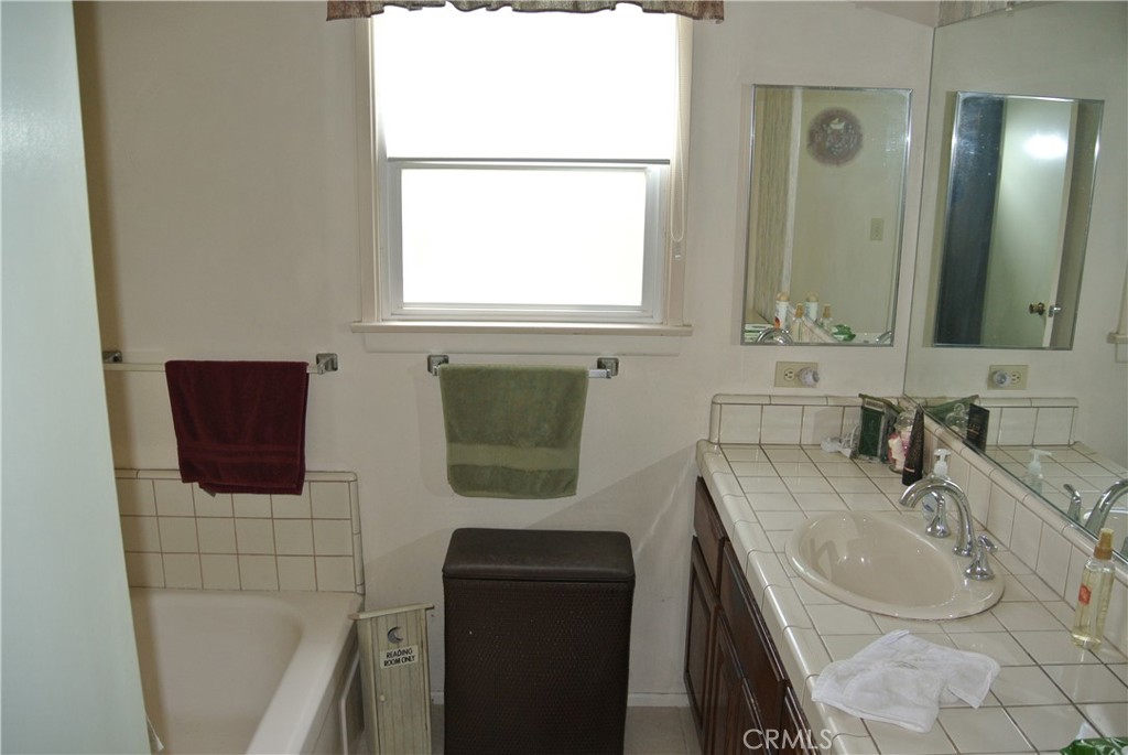 6460 Dos Rios Road Downey, CA 90240 - Photo 17 of 34 a bathroom with a sink a toilet and mirror