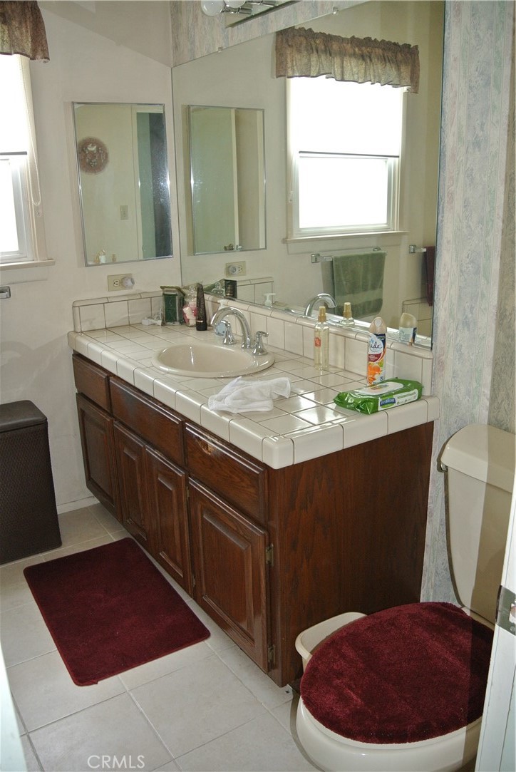 6460 Dos Rios Road Downey, CA 90240 - Photo 18 of 34 a bathroom with a sink a toilet and a mirror