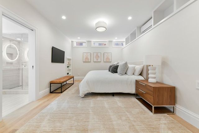 a spacious bedroom with a bed and a flat screen tv