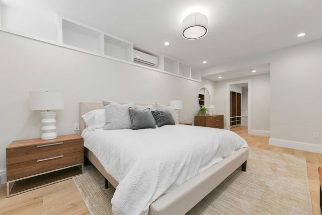 a spacious bedroom with a bed and a dresser