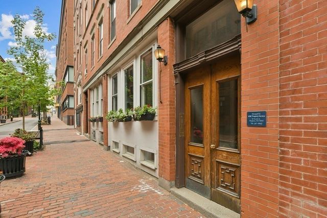 a view of a brick buildings with potted plants