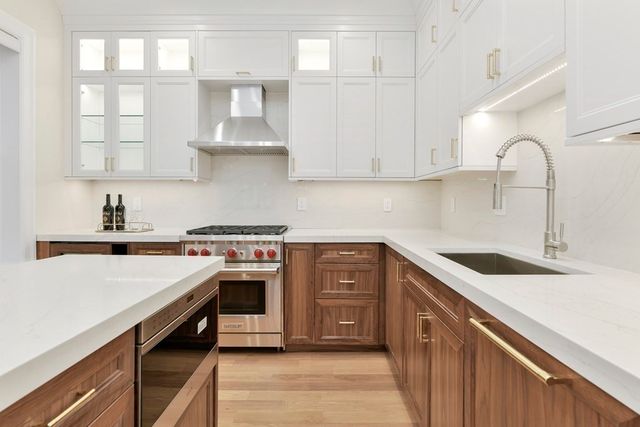 a kitchen with stainless steel appliances granite countertop a sink stove and cabinets