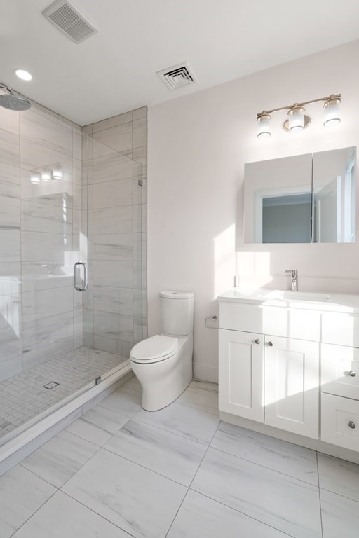 134 Chelsea Street, Unit 1 Boston, MA 02128 - Photo 7 of 13 a bathroom with a double vanity sink mirror and toilet