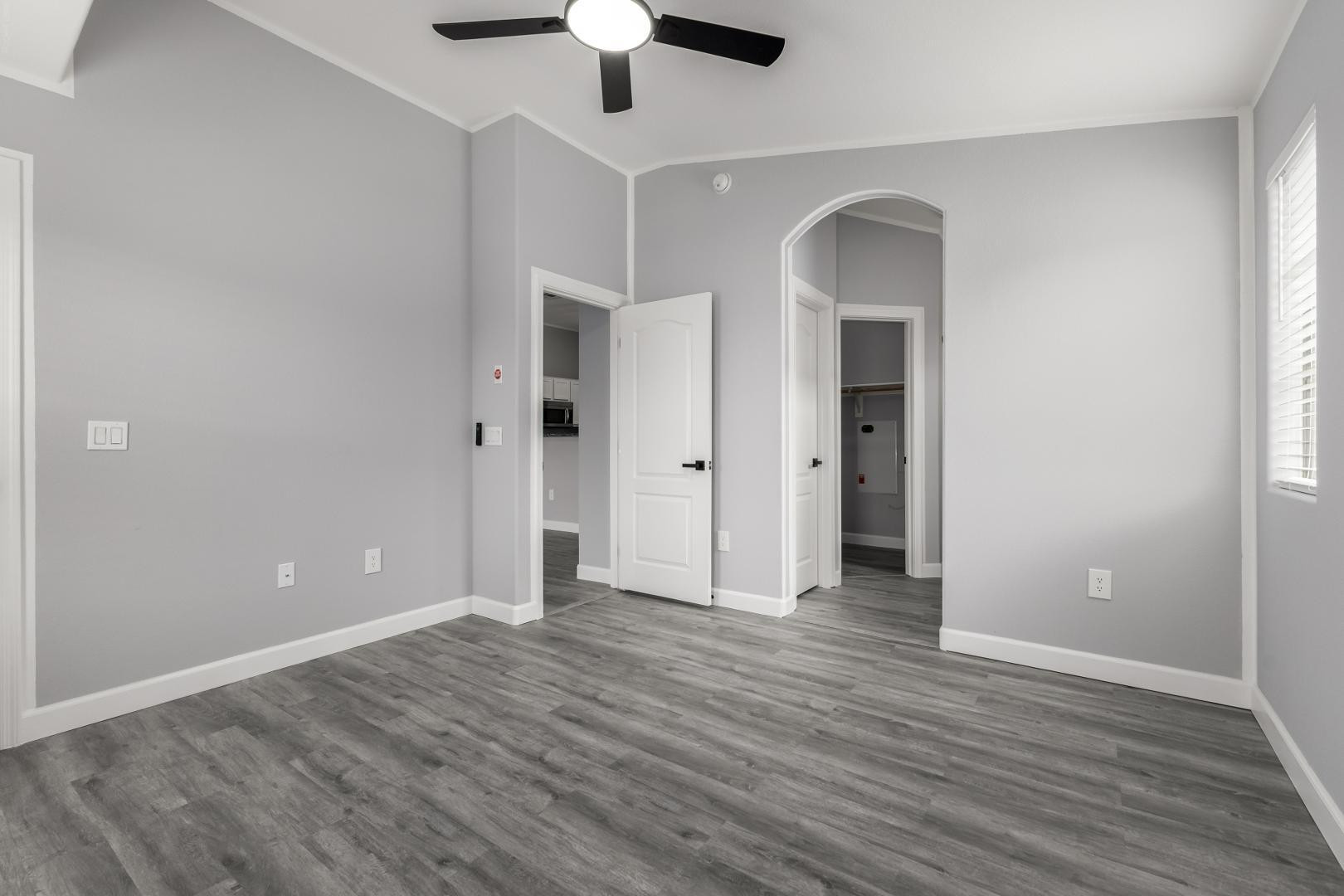 1350 South Greenfield Road, Unit 2205 Mesa, AZ 85206 - Photo 14 of 42 an empty room with wooden floor and ceiling fan