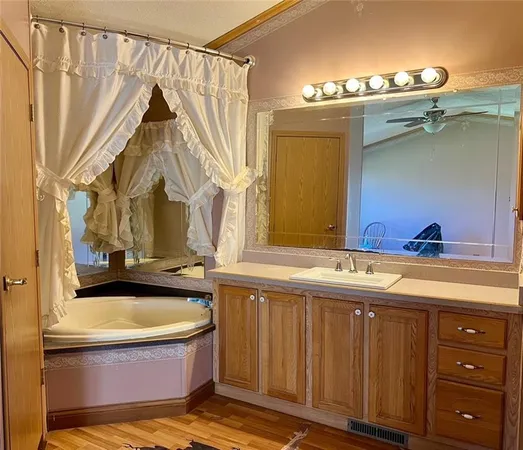 a bathroom with a tub sink and mirror