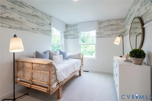 a bedroom with a bed a mirror and next to a window