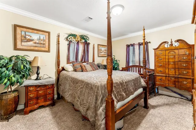 a bedroom with a bed a dresser and potted plants