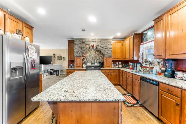 a kitchen with stainless steel appliances granite countertop a sink stove and refrigerator