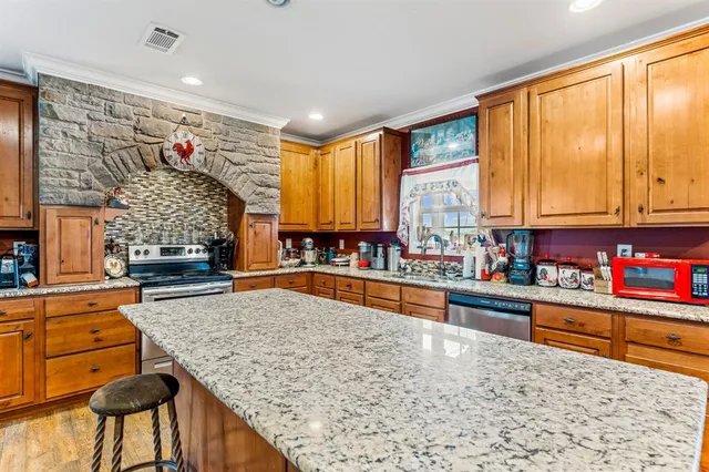 a kitchen with stainless steel appliances granite countertop sink stove and granite counter top