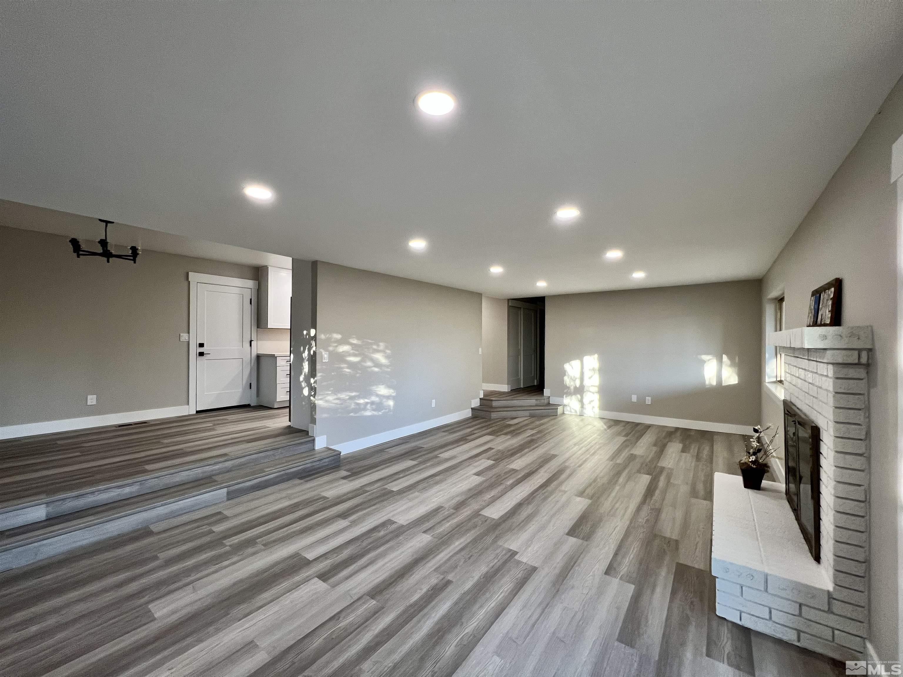 4475 Apollo Drive Carson City, NV 89706 - Photo 26 of 40 a view of an empty room with wooden floor and a kitchen
