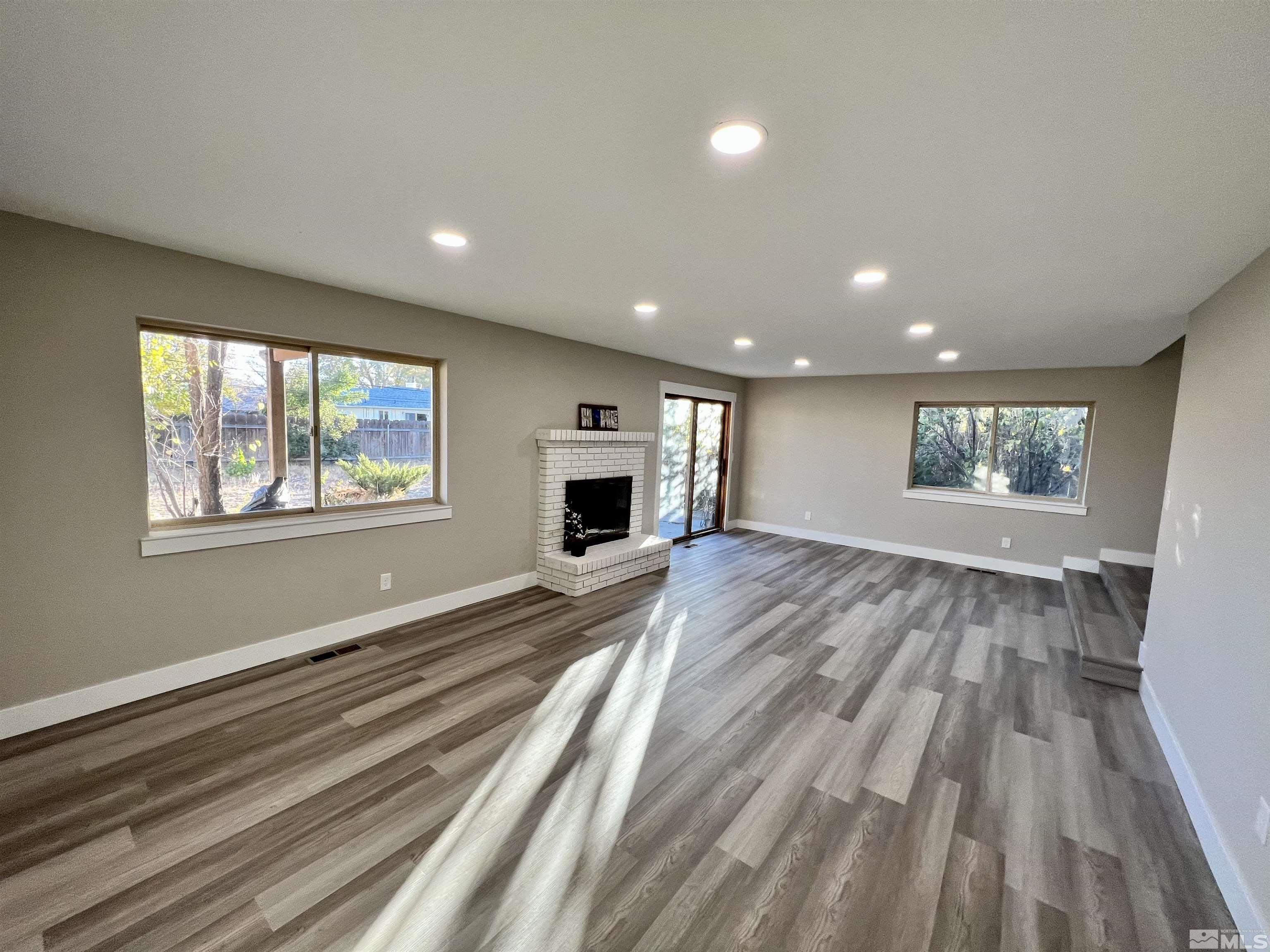 4475 Apollo Drive Carson City, NV 89706 - Photo 5 of 40 a big room with wooden floor fireplace and windows