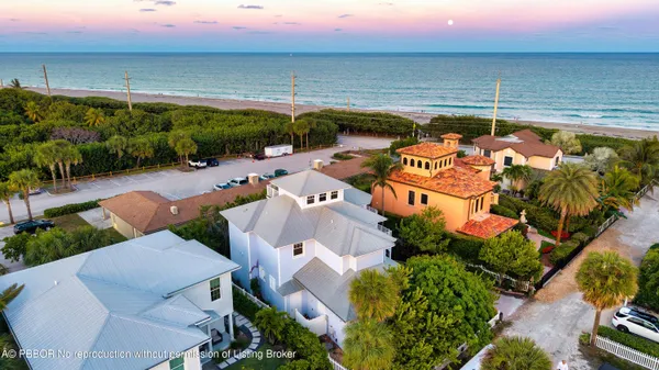 an aerial view of a house with swimming pool and outdoor seating