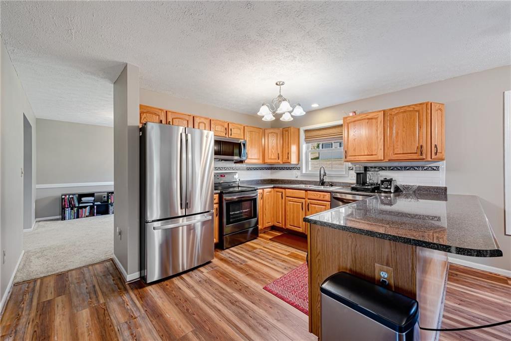 116 Mason Drive Windber, PA 15963 - Photo 10 of 35 a kitchen with granite countertop a refrigerator a sink dishwasher stove and oven with wooden floor