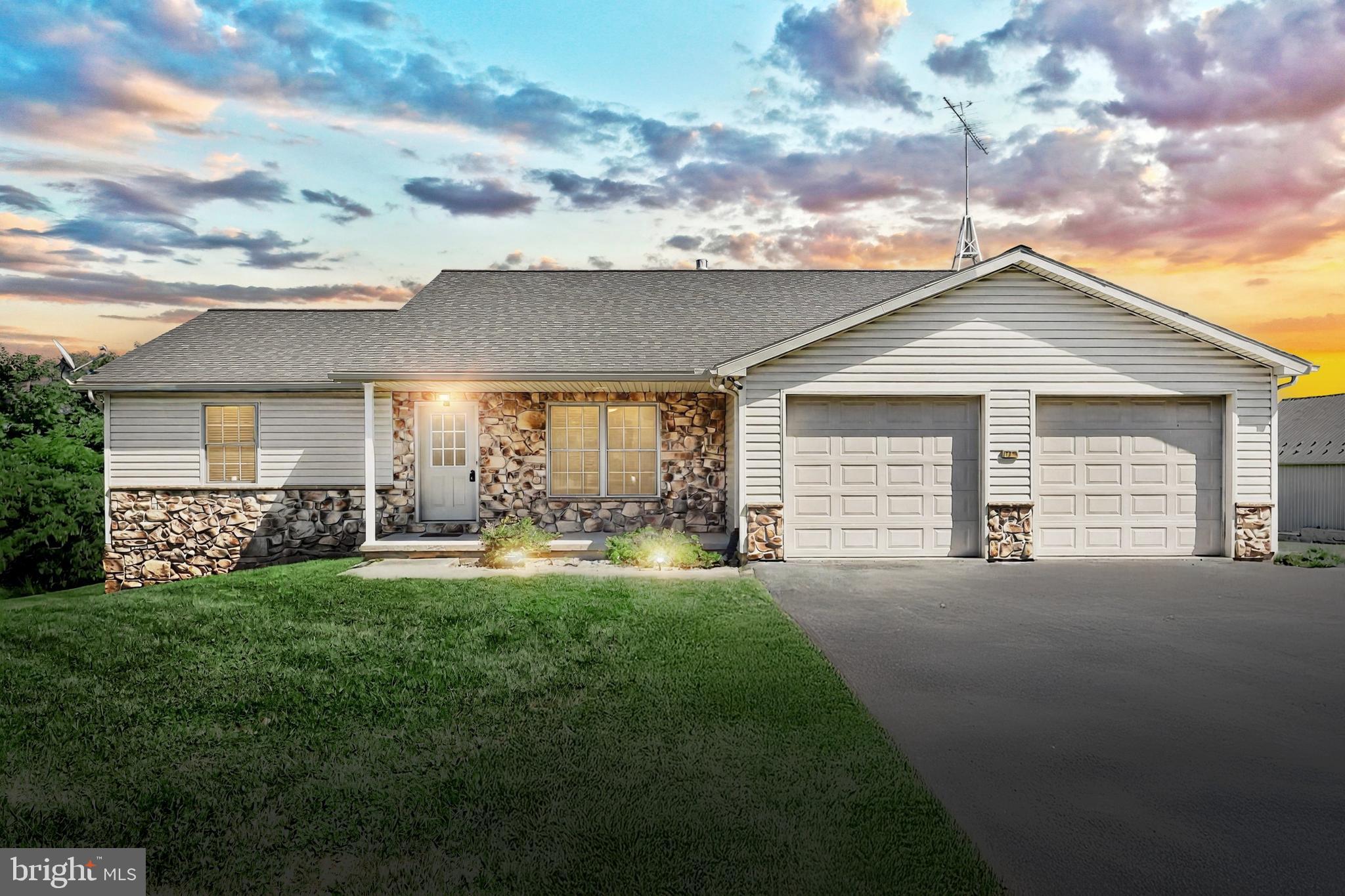 a front view of a house with a garden and yard