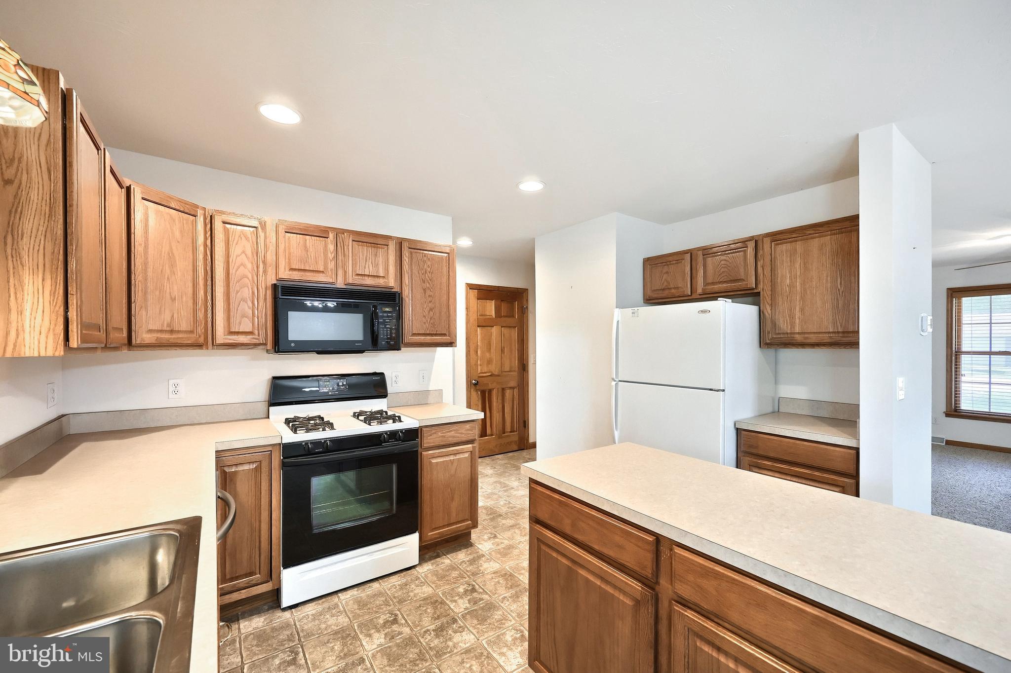 965 East Butter Road York, PA 17406 - Photo 26 of 54 a kitchen with a refrigerator a stove top oven a sink and cabinets