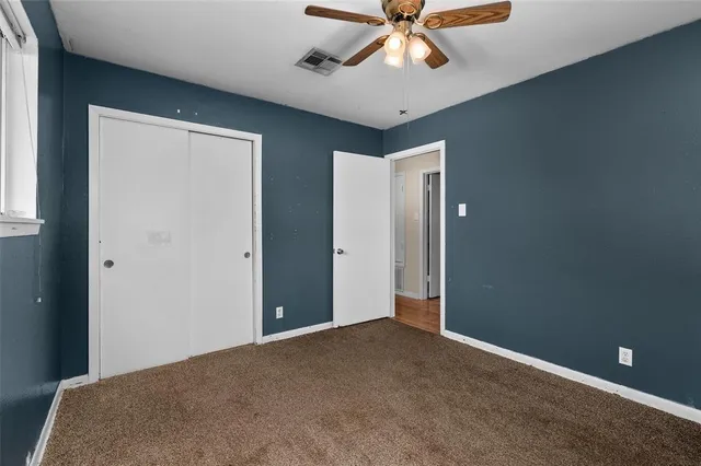 a view of a livingroom with a ceiling fan and window