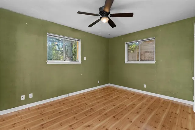 a view of empty room with wooden floor
