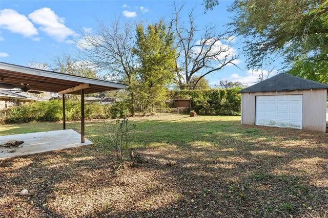 a view of a backyard with tree