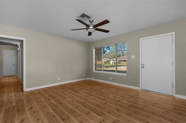 wooden floor in an empty room with a window