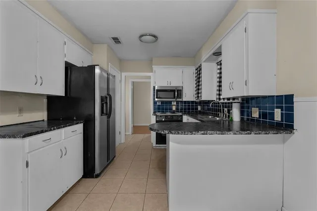 a kitchen with stainless steel appliances granite countertop a sink a stove and refrigerator