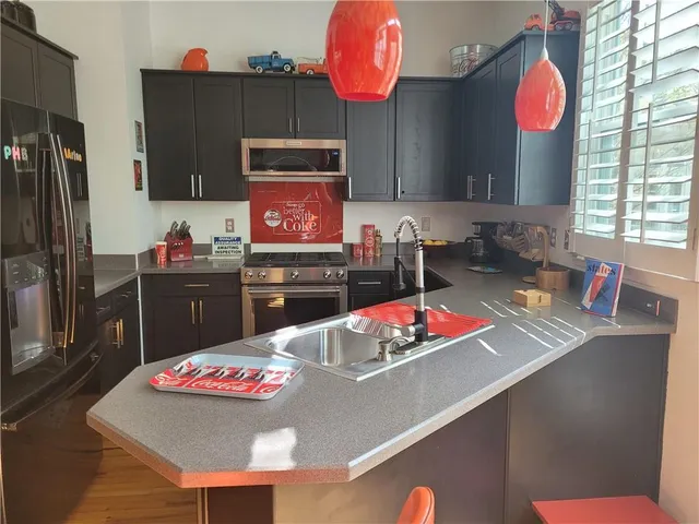 a room with stainless steel appliances kitchen island granite countertop furniture and a view of kitchen