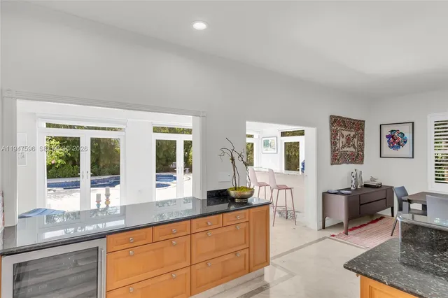 a living room with granite countertop couches a coffee table and large window with wooden floor