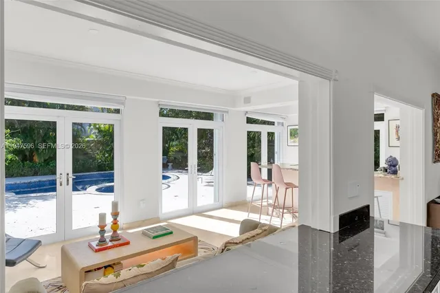 a living room with patio furniture and floor to ceiling windows