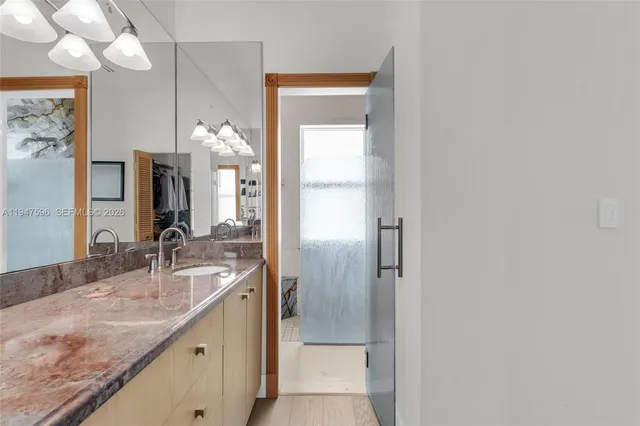 a bathroom with a granite countertop sink and a mirror