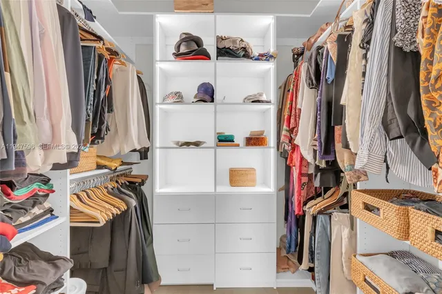 a view of walk in closet with clothes and shoes