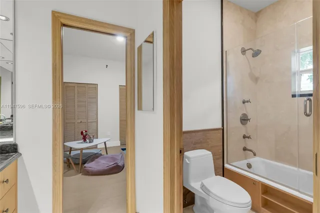 a bathroom with a toilet a tub and shower