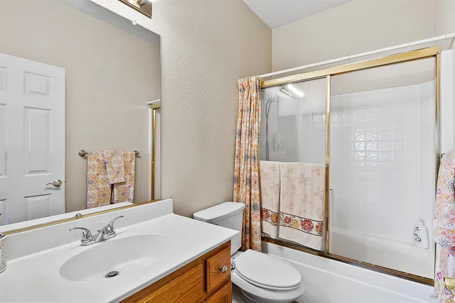 a bathroom with a sink vanity mirror and toilet