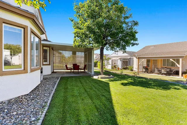 a view of house with backyard and outdoor seating