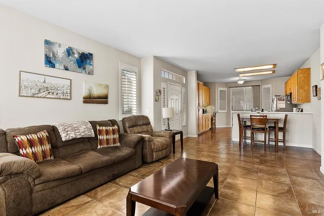 a living room with furniture and a view of kitchen