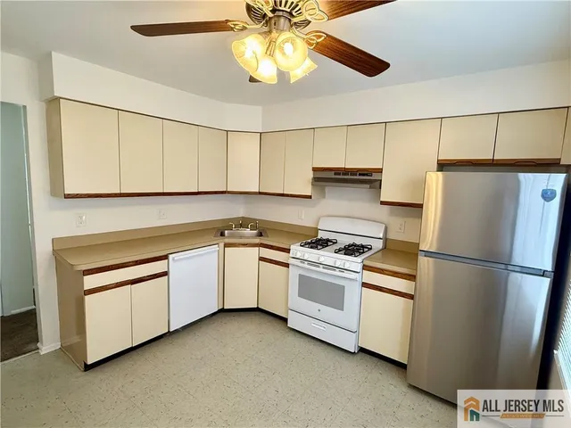 a kitchen with stainless steel appliances granite countertop a refrigerator a stove a sink and a refrigerator