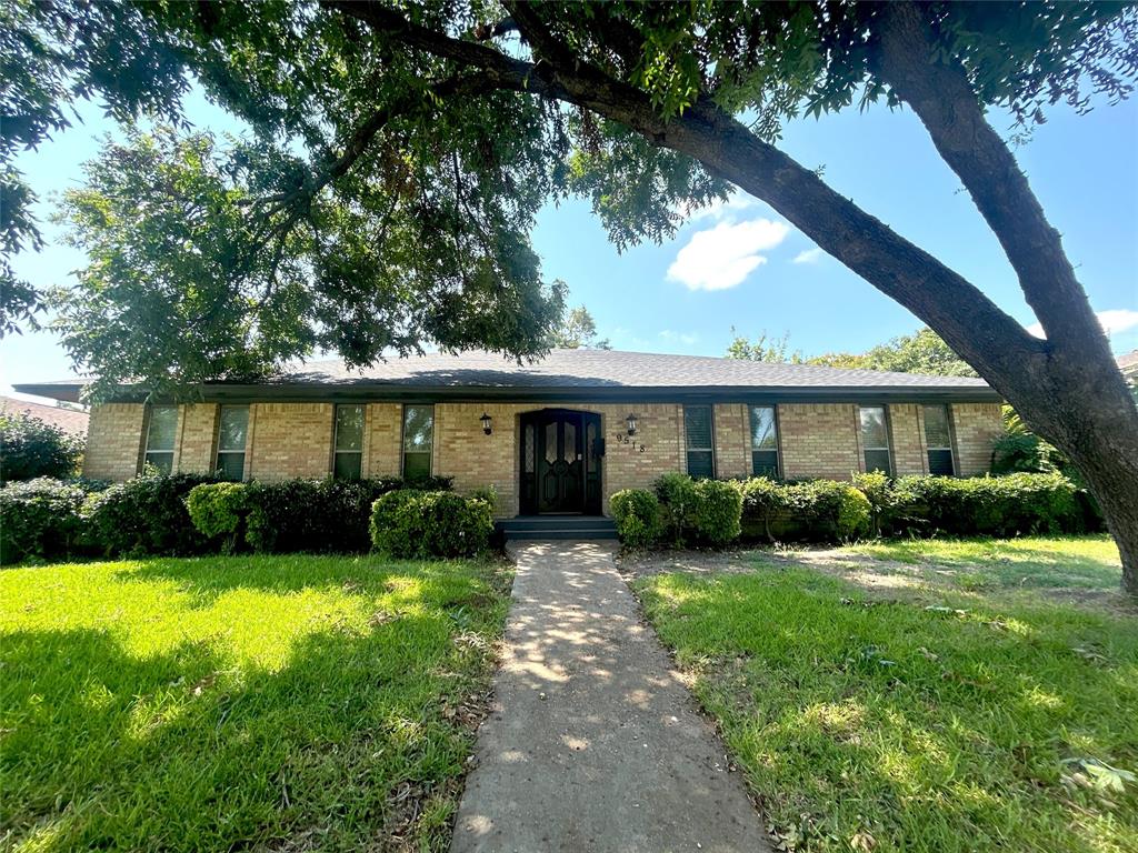 a front view of a house with yard and green space