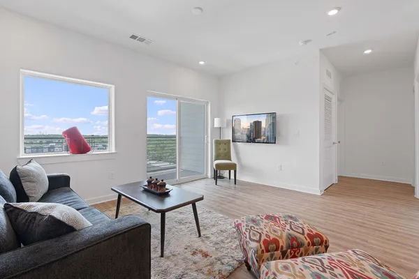 a living room with furniture and a wooden floor