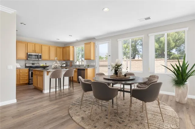 a kitchen with stainless steel appliances granite countertop wooden cabinets a sink and dishwasher with wooden floor